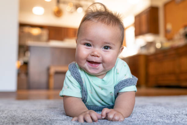 Smiling baby laying on carpet | Fantastic Floors